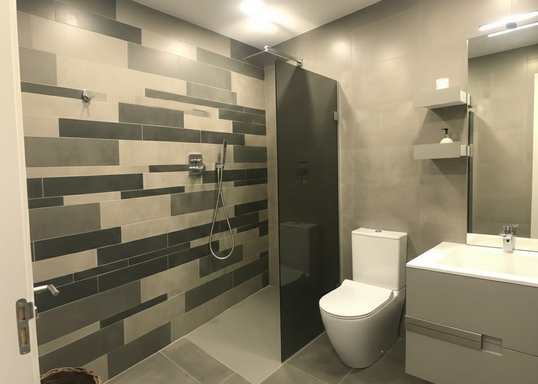 The shower room, in banded grey tile.