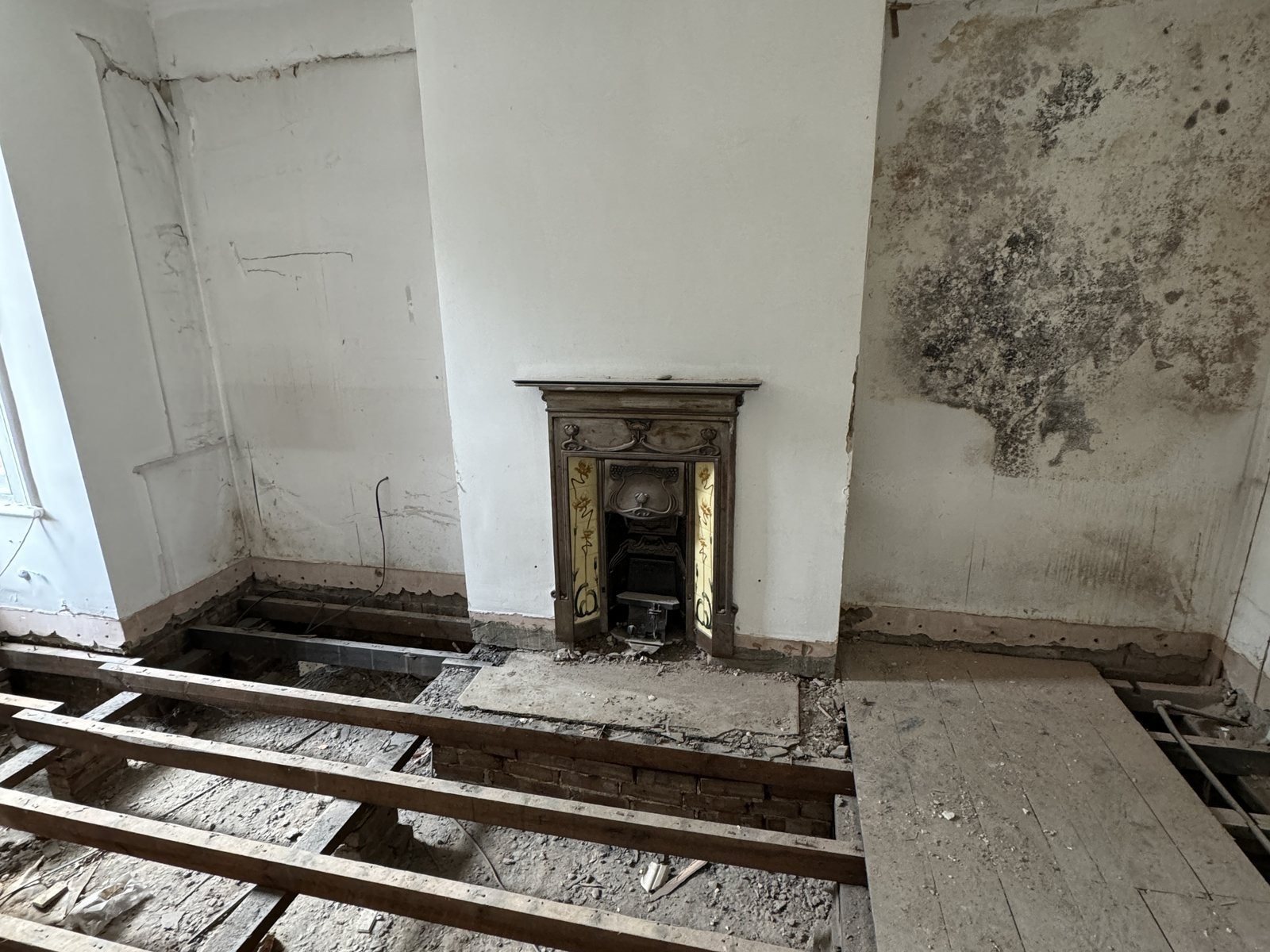 Damp staining on the wall above the fireplace, opened up.