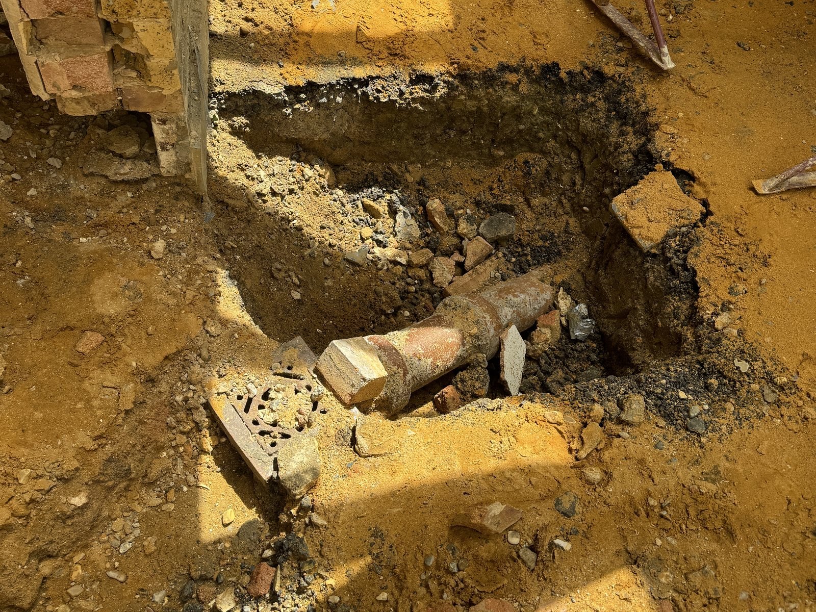 A clay drain exposed in the trench. All the existing drainage was traced and checked.