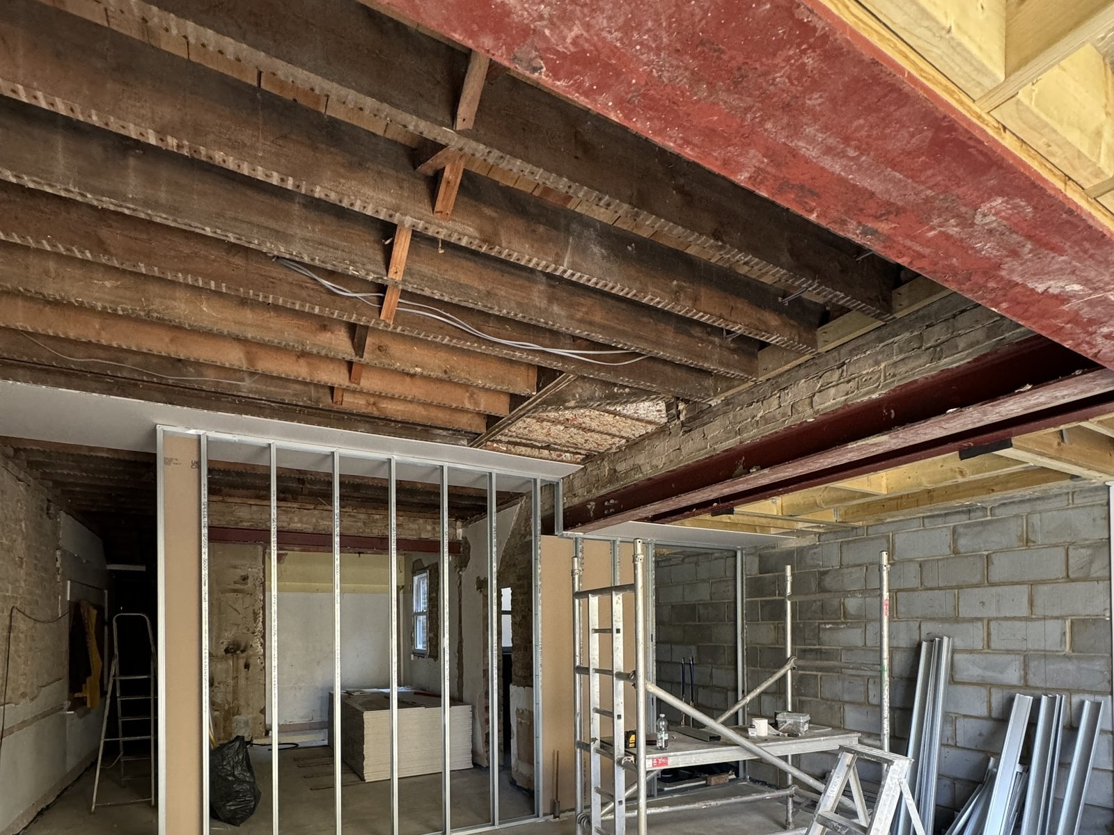 Roof joists on, and the first stud partitions going up inside.