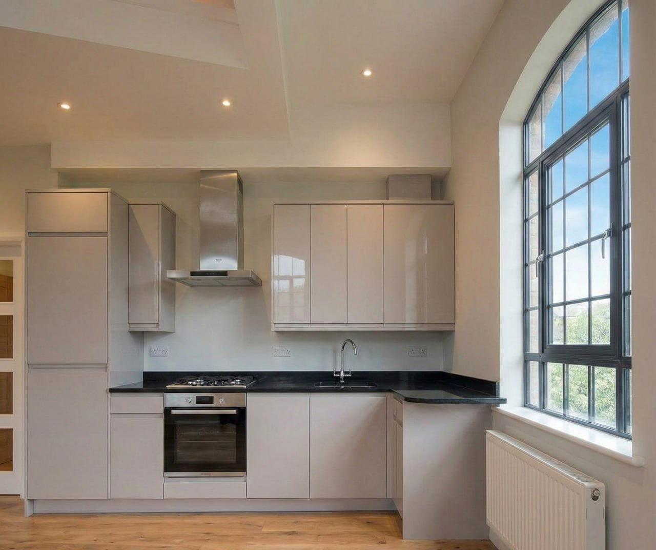 Inside the first apartment: the kitchen set against an arched window.