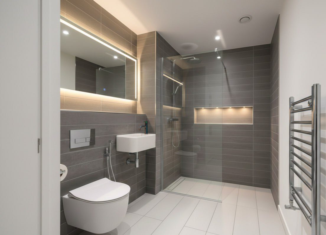 The shower room, with a lit mirror the width of the wall.